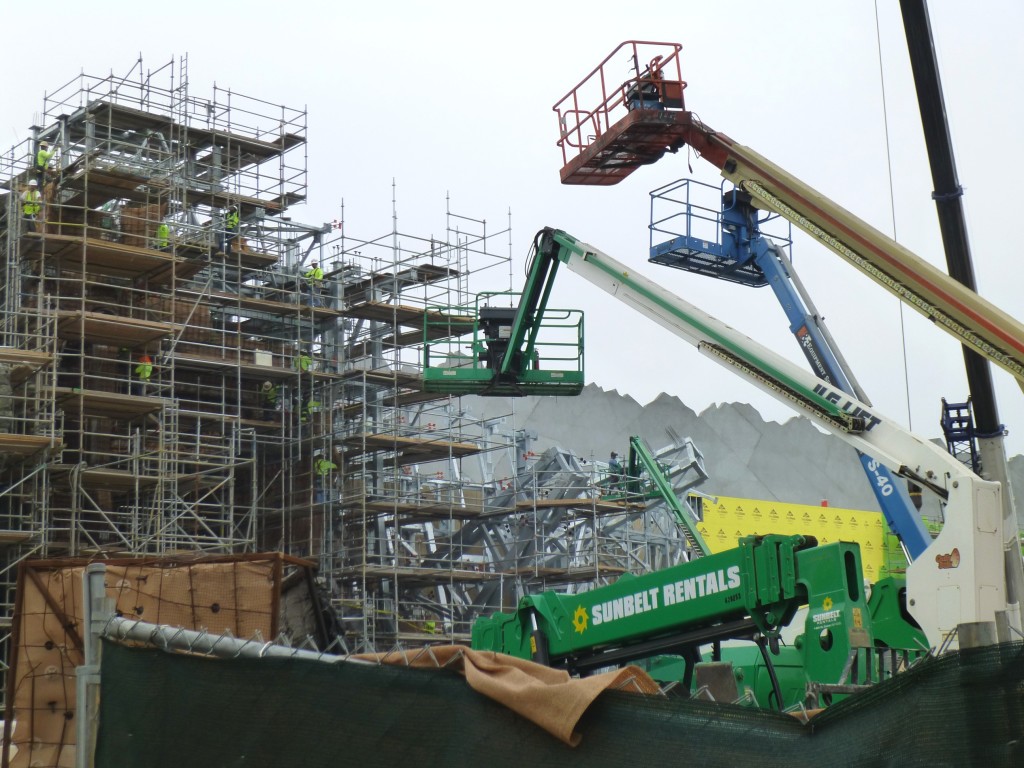 Many cranes and cherry pickers