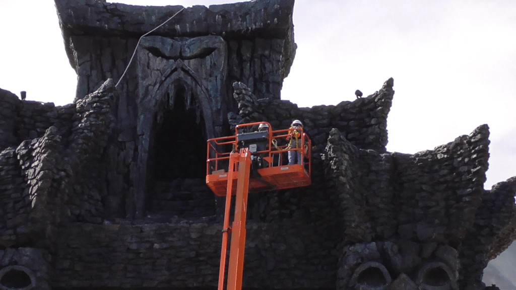 Workers installing spot lighting atop temple