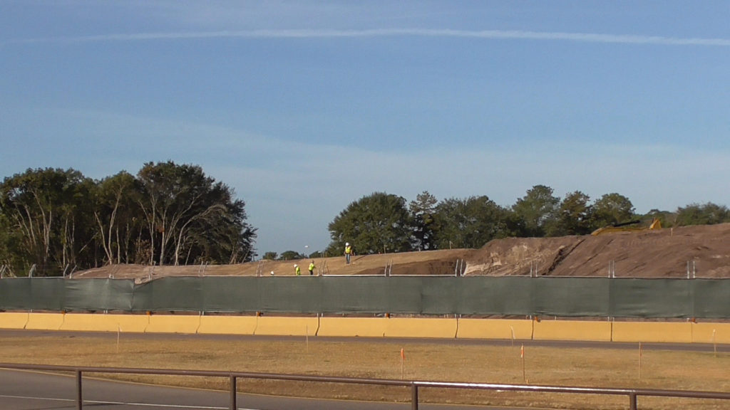 Wide view of new berm. Will probably be covered in grass and new plants will be added behind it soon to better block the area