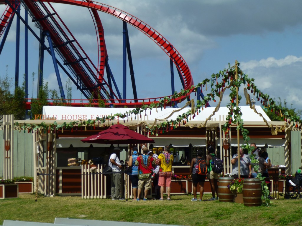 People lining up for food with the Shiekra coaster looming above