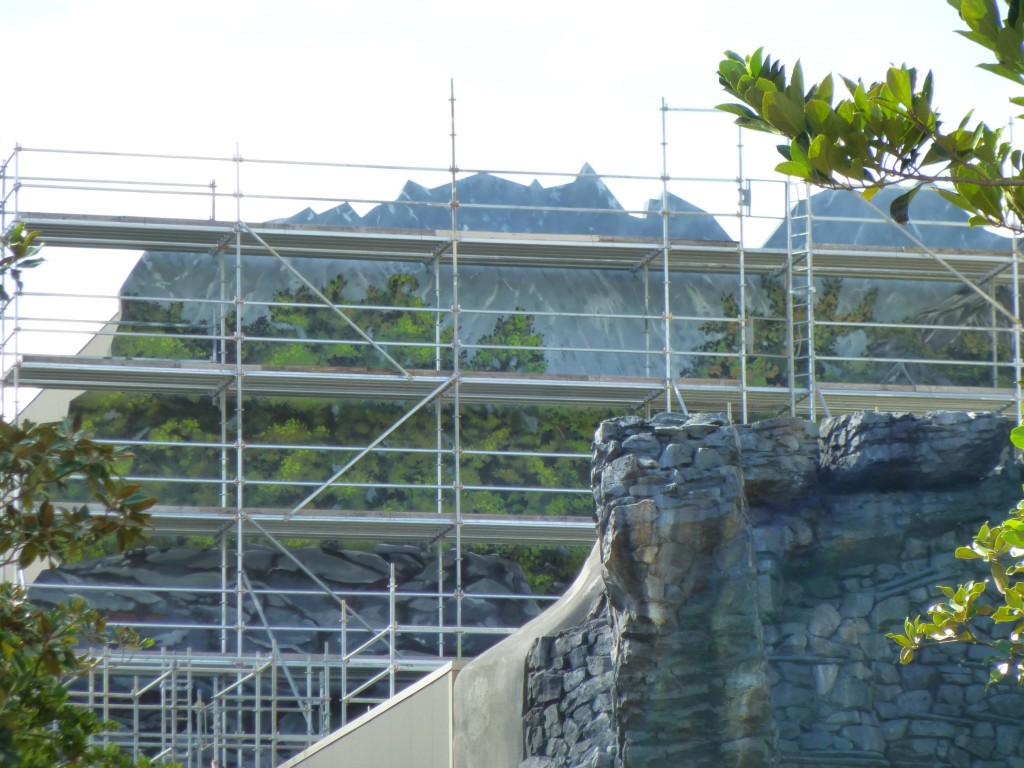 Detail of the mural on the mountain range featuring 2D brickwork, trees, and mountains