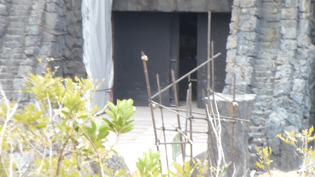 Ride show doors that open/close behind large gates to block light after vehicle enters. Skulls on spears can be seen in foreground