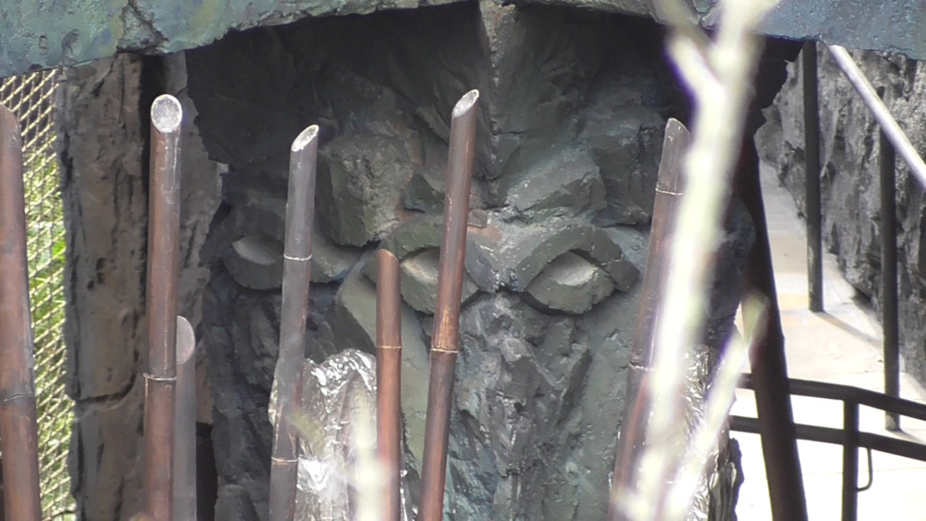 Creepy faces on columns in outdoor queue area