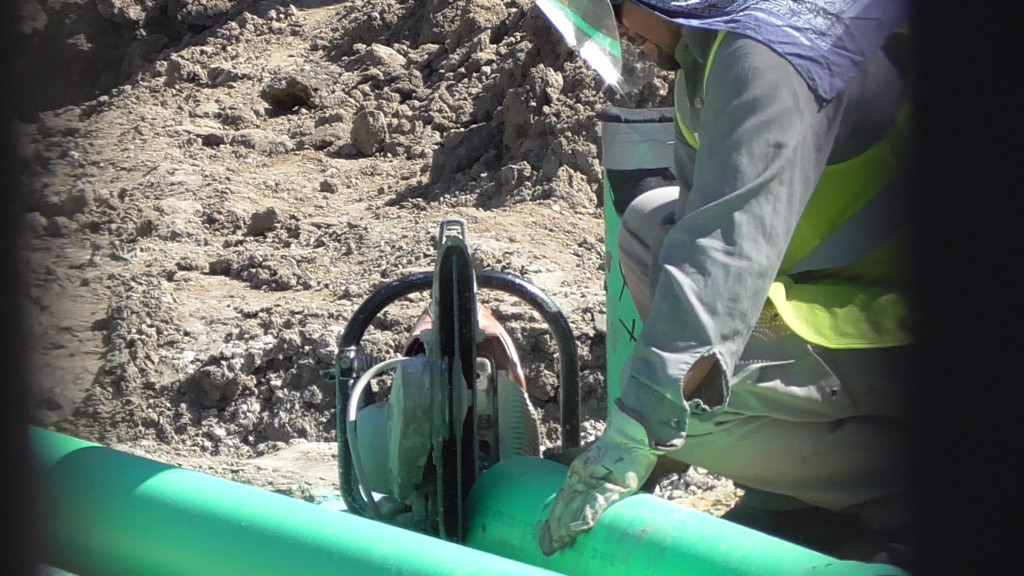 Pipes being cut in front of queue building