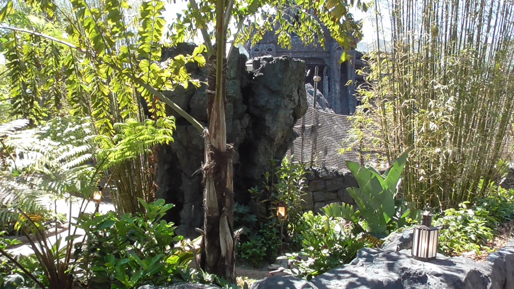 Beautiful stone walls with lanterns and landscaping separating pathway from outdoor queue paths