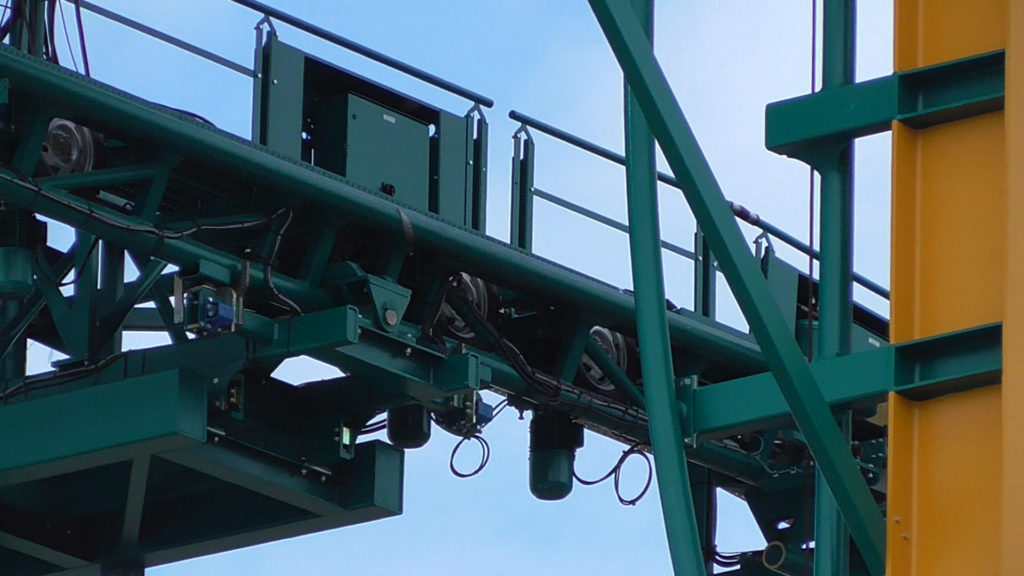 Close up of lift track meeting ride track. Motorized tires propel cars forward onto ride track