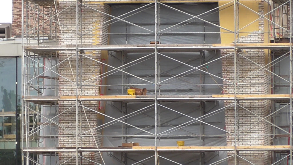 Bricks appear to be fake and are applied in prefab sections. I wonder if they will be painted after installed