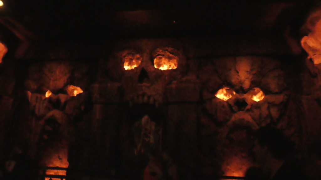 Animatronic woman in a room filled with skull and ape carvings filled with an impressively real looking fire musion effect