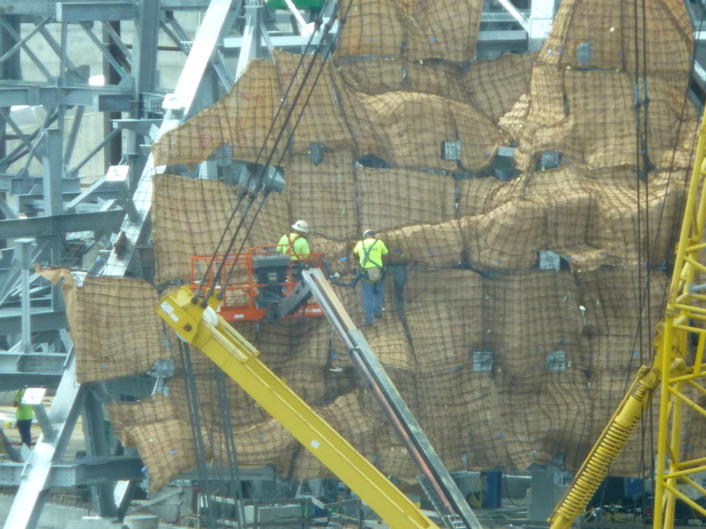 Lots of workers in rock climbing gear working on the volcano