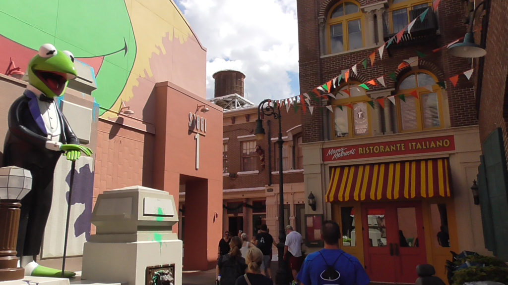 A normal city alley up against an incredibly strange out of place messy soundstage